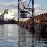 El puerto de Tarragona adapta el muelle de Cataluña para recibir barcos más grandes con mineral de hierro  El Puerto de Tarragona está realizando mejoras en el muelle de Cataluña para poder recibir barcos de carga de mayor tamaño, dedicados al tráfico de mineral de hierro. Con una inversión de 2,1 millones de euros, el proyecto tiene como objetivo modernizar la infraestructura portuaria para dar respuesta a las nuevas necesidades derivadas de este tráfico.  El principal componente de este proyecto será la instalación de 28 defensas marítimas, diseñadas para absorber el impacto de los grandes barcos previstos. Las defensas actuales, instaladas en 2015, necesitan ser actualizadas para gestionar la mayor energía de atracaje de estos nuevos buques.  Tras un detallado estudio de ingeniería, el puerto ha decidido instalar un modelo de defensa tipo escudo, teniendo en cuenta factores como la capacidad de absorción de energía (2.642 KNm), la presión sobre el casco de los barcos, las dimensiones del muelle y la necesidad de acercar los barcos al muelle.  El proceso de instalación se realizará en varias fases, comenzando con la colocación de 15 defensas en la primera etapa, y las 13 restantes en la segunda. Se espera que la instalación de las 28 defensas dure un total de 7 meses.  Esta modernización forma parte de una estrategia más amplia para consolidar el tráfico de mineral de hierro en el puerto, un tipo de carga que poco a poco reemplazará al carbón, cuya actividad está disminuyendo. Con estos cambios, el muelle podrá recibir barcos de mayor capacidad, mejorando la eficiencia en las operaciones de carga y descarga y aumentando la competitividad logística del puerto.